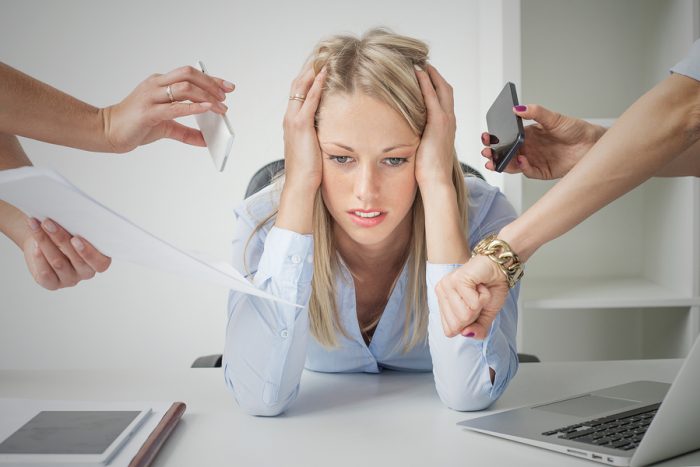 Depressed woman overloaded with stuff at work
